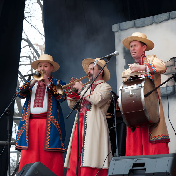 Three women are engaged in a pottery class, working with clay and tools at a table filled with supplies in a craft studio